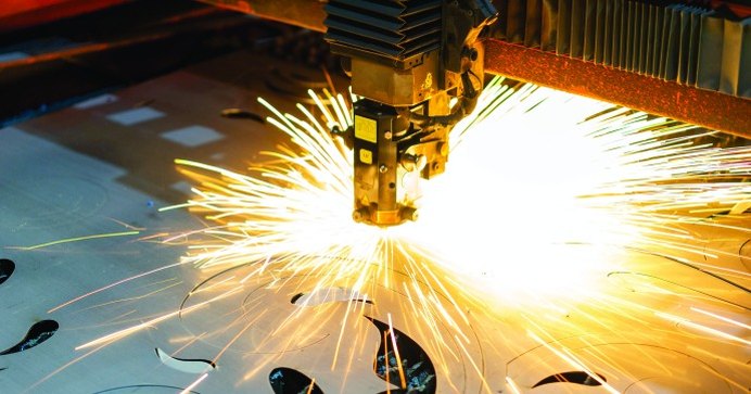 Laser cutting head cutting steel sheet with a spray of sparks