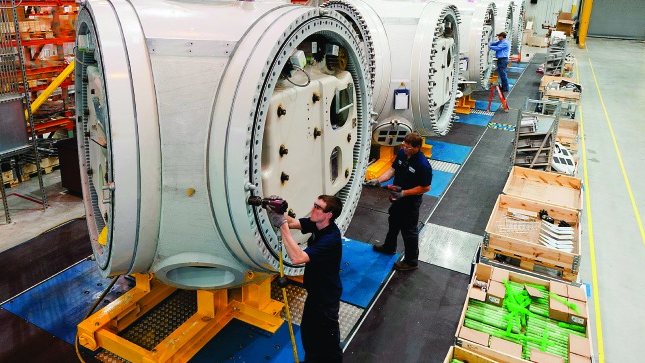 Fitters assembling large machine housings on an assembly line