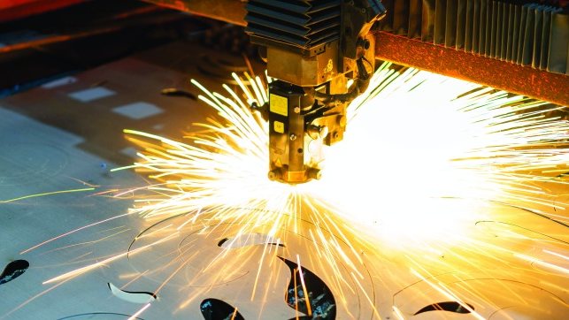 Laser cutting head cutting steel sheet with a spray of sparks